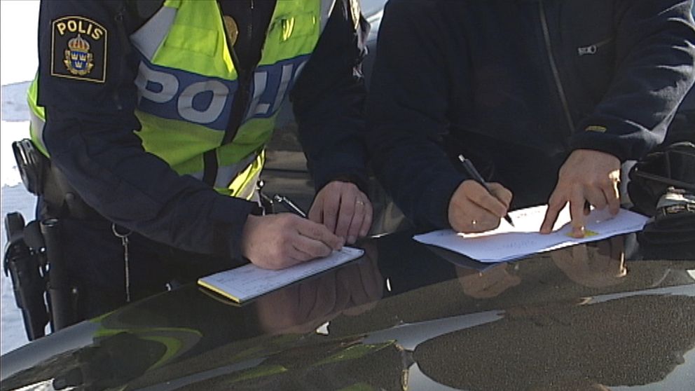 Arkivbild polisman skriver i dokument i samband med kontroll långtradare