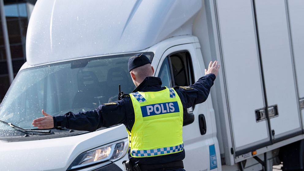 Bilden visar när en polis vinkar en lätt lastbil vid en gränsövergång mot Sverige.