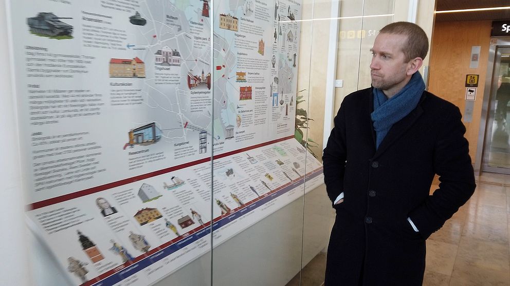 Strängnäs kommunalråd Jacob Högfeldt tittar på en monter som visar Strängnäs historia.
