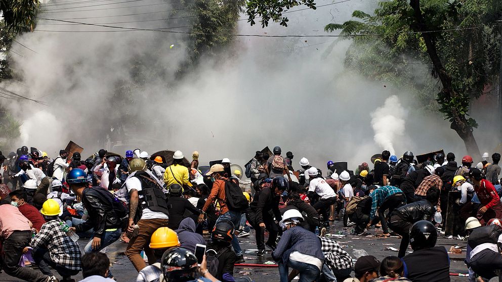 Demonstranter reagerar efter att polisen skjutit tårgas i Mandalay på onsdagen.