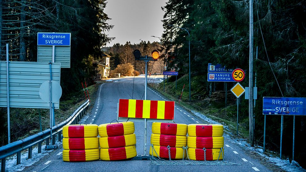 Rödoch gulmålade däck vid en väg där en vägskylt markerar gränsen mellan Sverige och Norge.