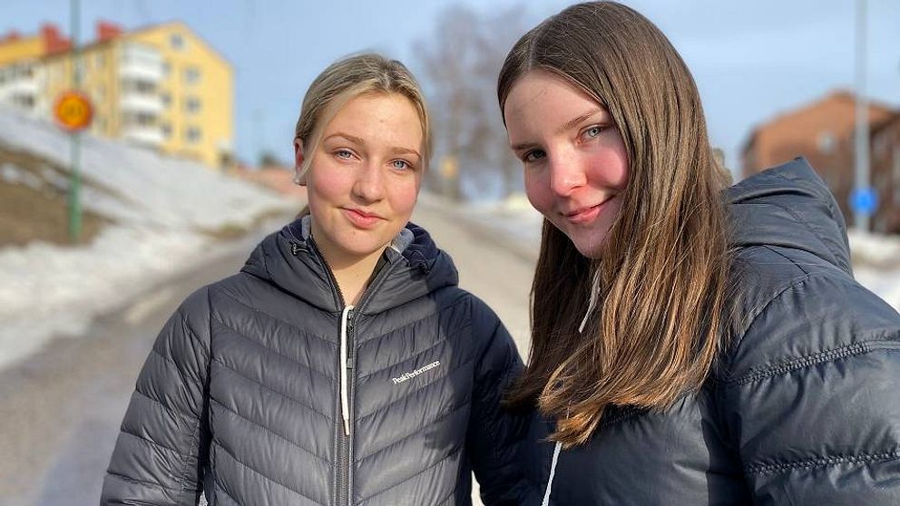 porträtt på två tjejer i vinterjackor på en gata i Sundsvall