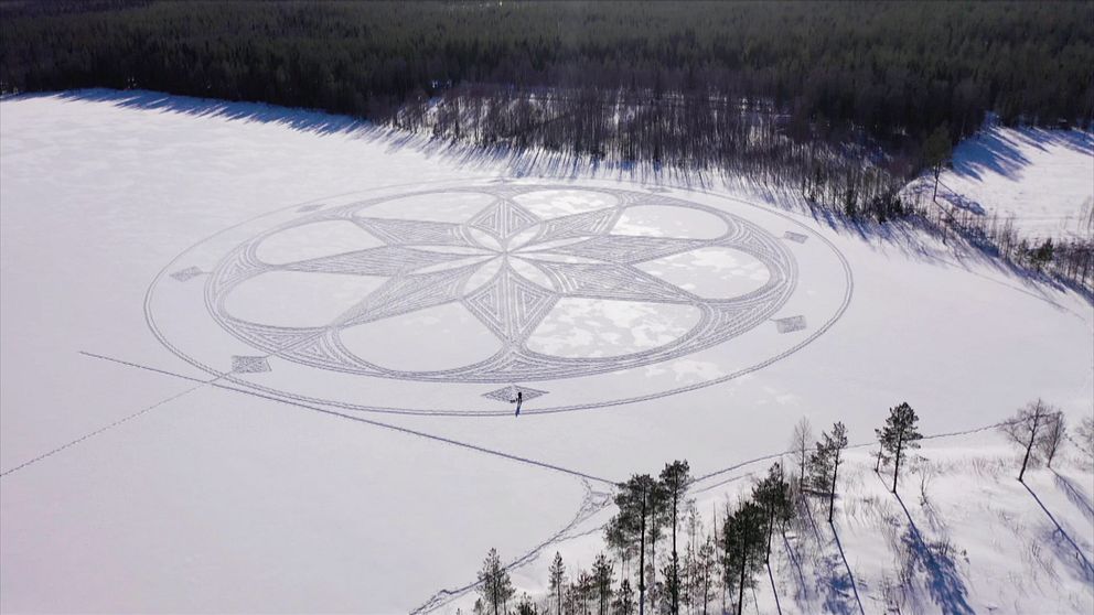flygbild över mönster i snön – en rund symmetrisk form, liknande en blomma eller stjärna