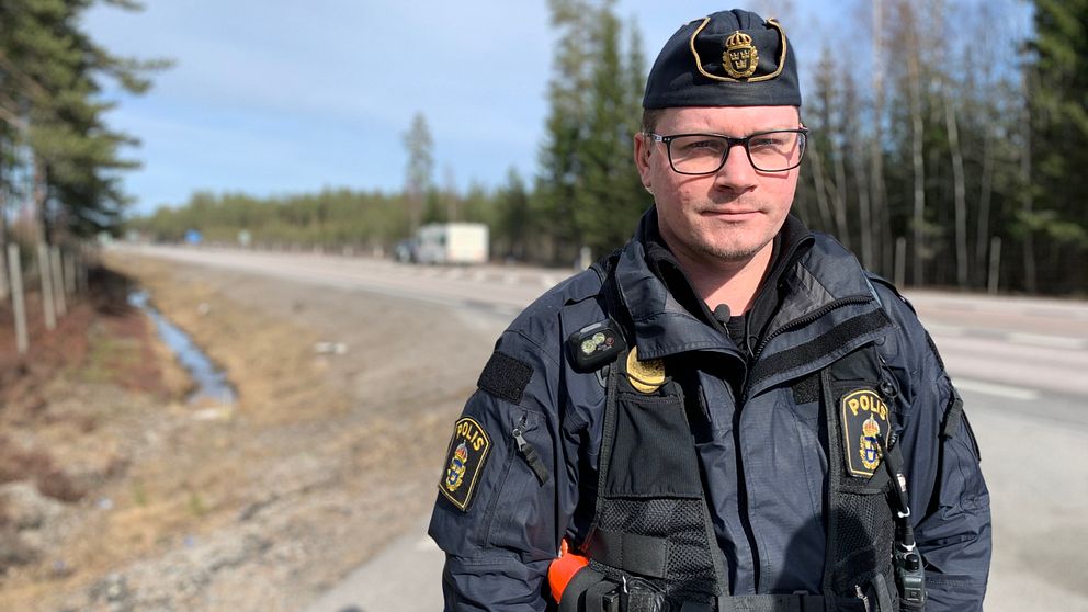 En manlig trafikpolis står vid sidan av motorväg E4 mellan Tönnebro och Gävle.