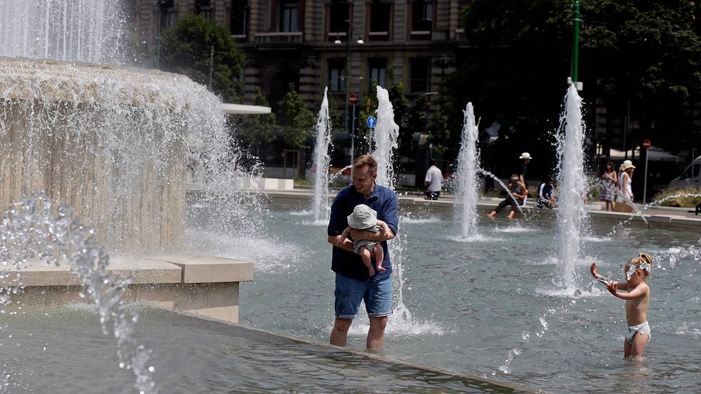 30-40 grader på kontinenten. En småbarnsfamilj svalkar sig i en fontän i Milano.