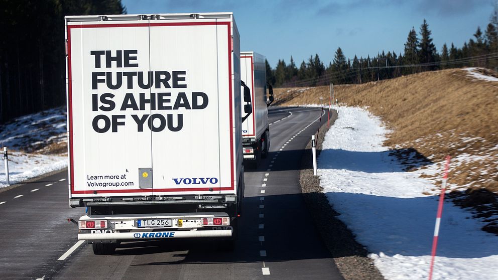 Bilden visar två lastbilar från Volvo som kör på en landsväg.