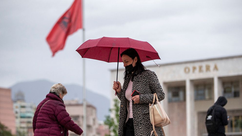 Personer promenerar på ett torg i Albaniens huvudstad Tirana.