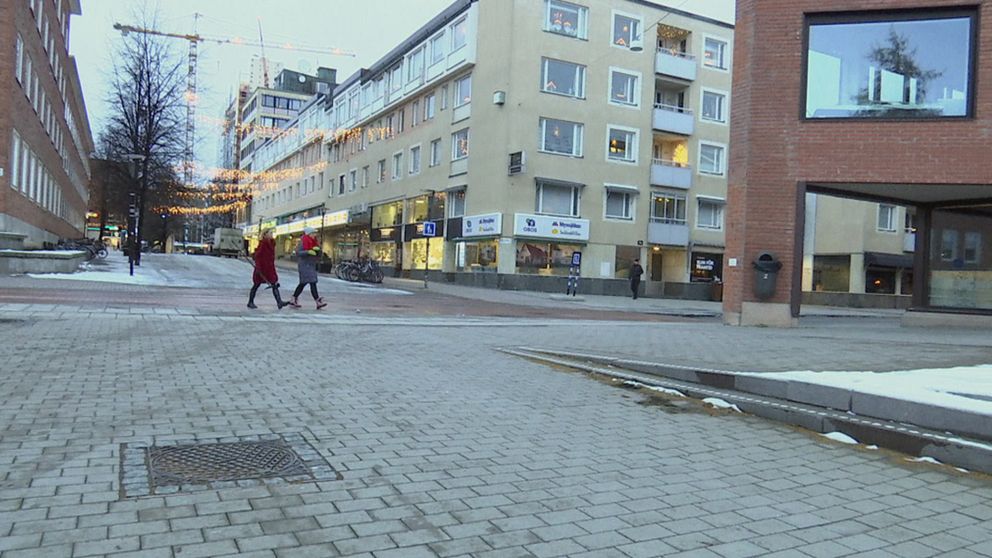 Två personer går genom en stadsmiljö.