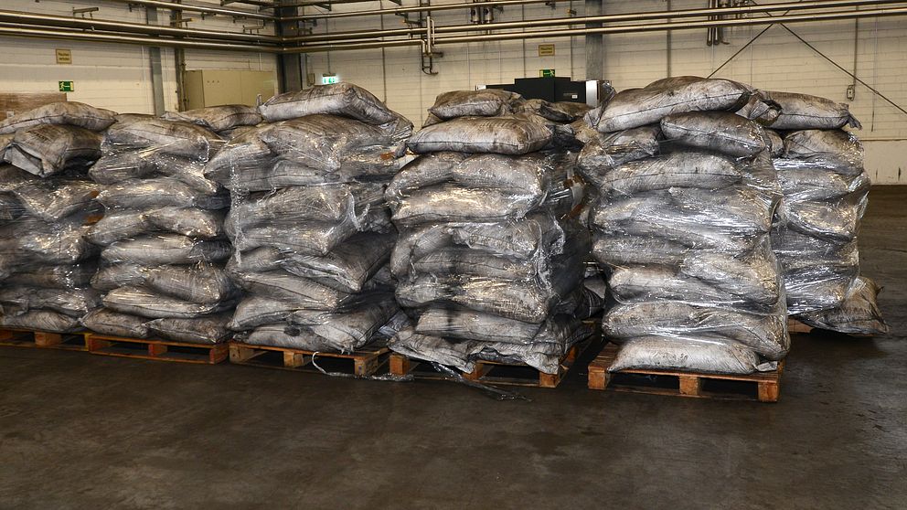 Ett stort antal säckar staplade på lastpallar i ett lagerutrymme.