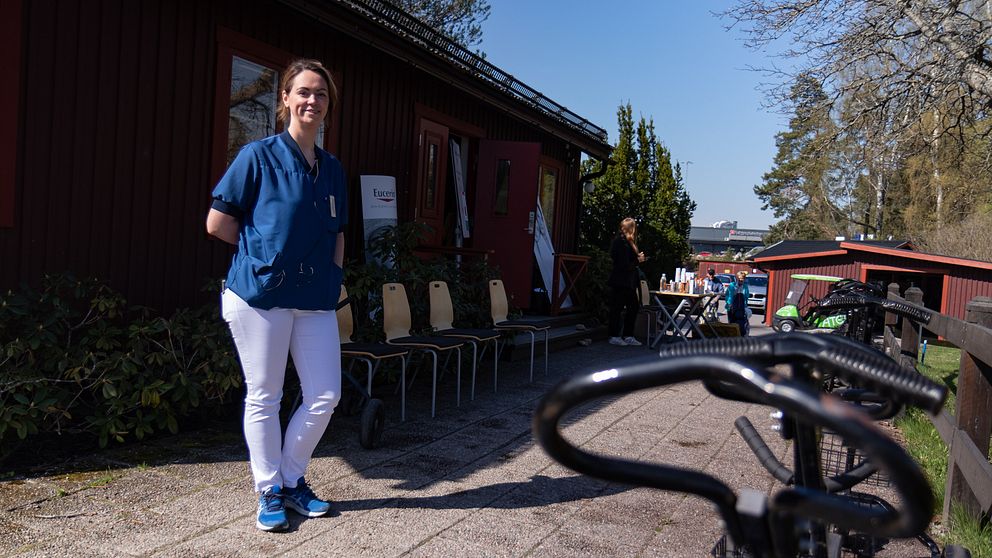 en kvinna i läkarblus och vita byxor på en uteplats på golfklubben i Gävle