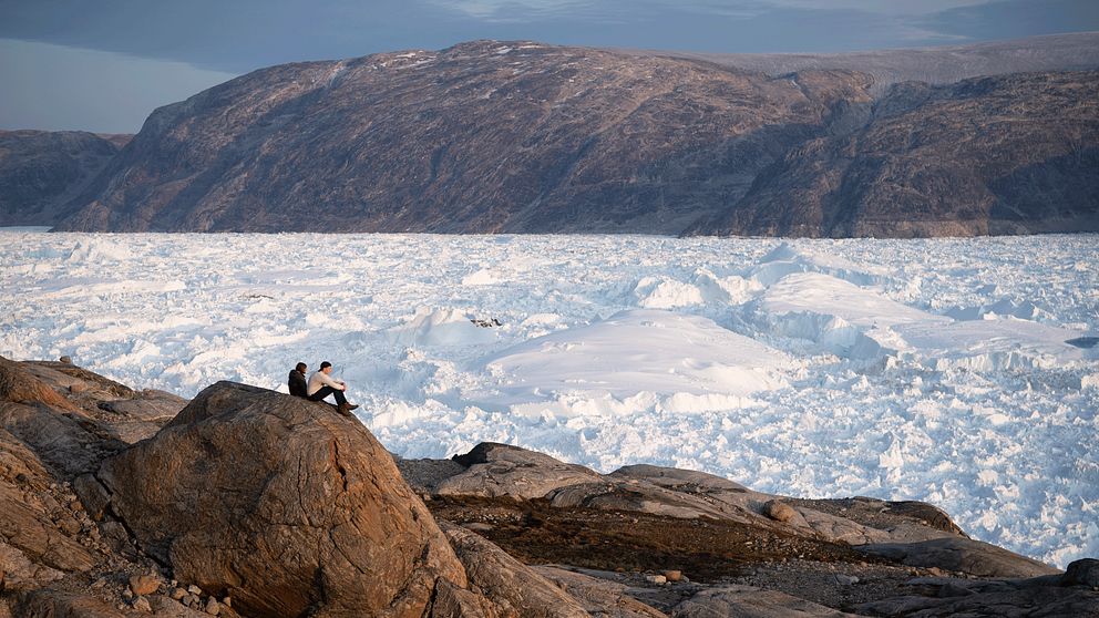 Två forskare vid glaciären Helheim i Grönland.