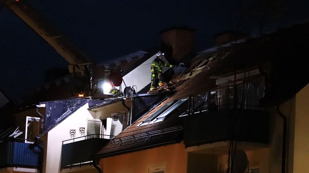 Brandman på taket till ett hyreshus.