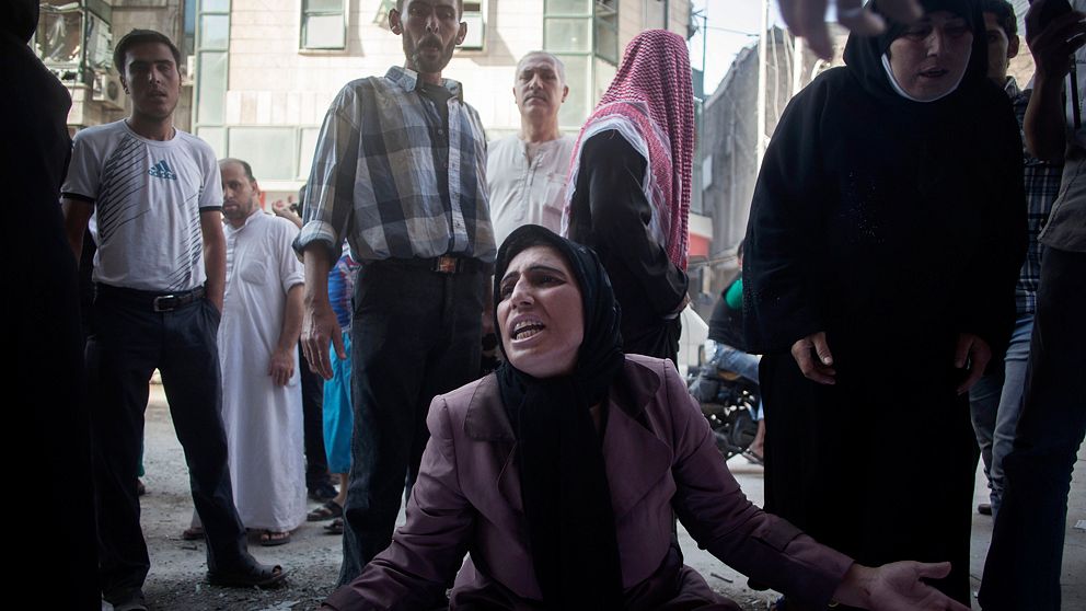 A woman cries near the body of her brother in front of Dar El Shifa hospital in Aleppo, Syria, Tuesday, Sept. 25, 2012. Over the past few months, rebels have increasingly targeted security sites and symbols of regime power in a bid to turn the tide in Syria's 18-month conflict, which activists say has left some 30,000 people dead.(AP Photo/Manu Brabo)