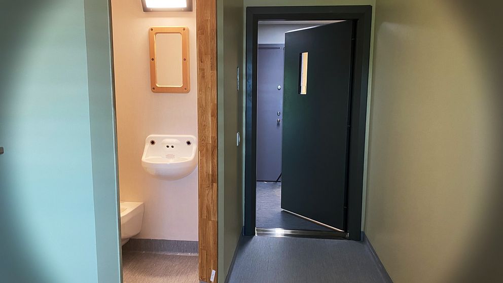 Interiör bild av en häktescell i Kriminalvårdens häkte i Växjö, fotograferat mot toaletten och dörren som står på glänt.