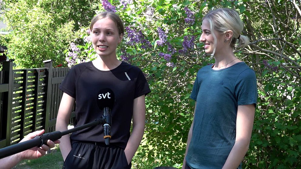 Två unga tjejer intervjuas av SVT framför en syrénbuske i solsken
