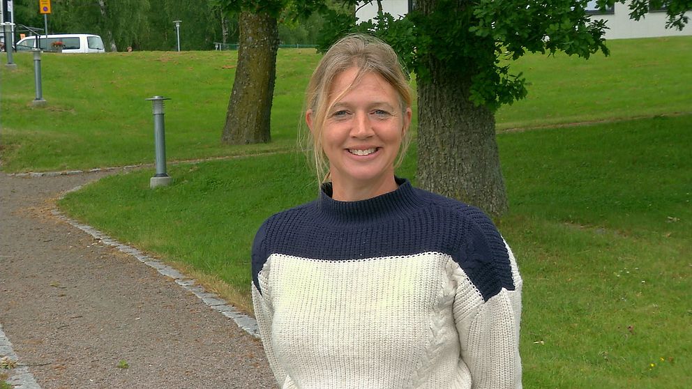 Anna-Karin Krijger framför gräsmattor och trädstammar