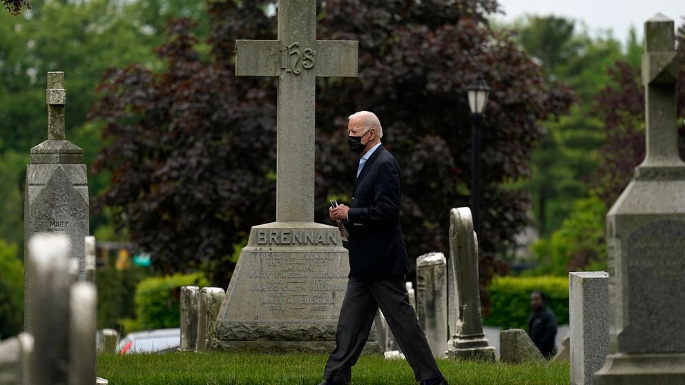 Joe Biden iförd munskydd på en kyrkogård.
