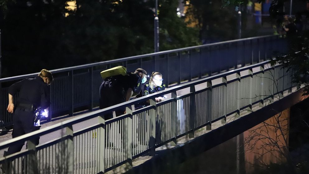 Polisens tekniker undersöker en gångbro vid brottsplatsen.