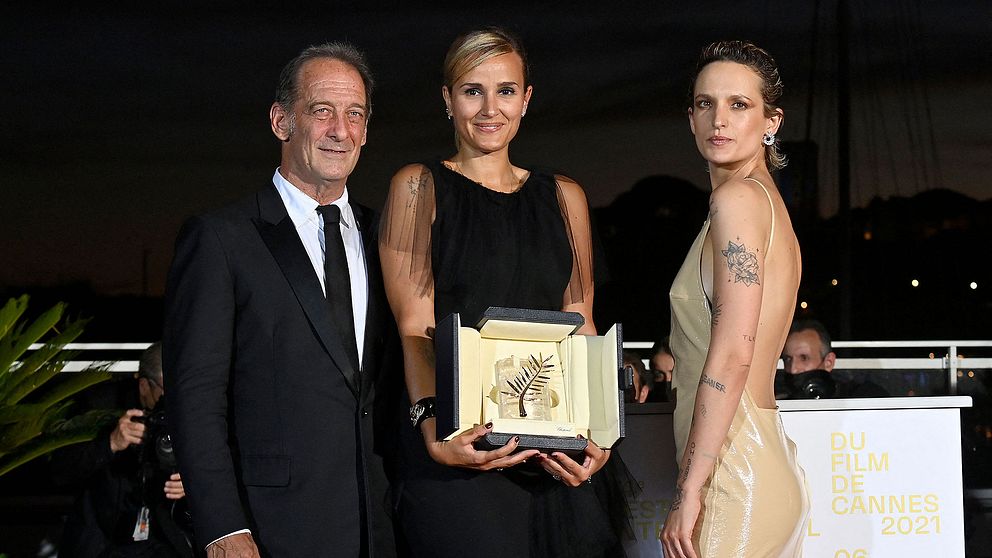 Franska regissören Julia Ducournau poserar med priset för guldpalmen tillsammans med skådespelarna Vincent Lindon och Agathe Rousselle.