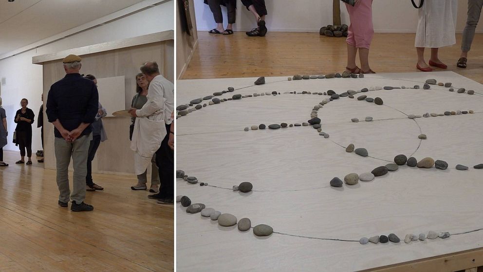 Till vänster några personer som står och pratar i en konsthall. Till höger ett konstverk med stenar som heter ”Kvinnlig energipunkt”.