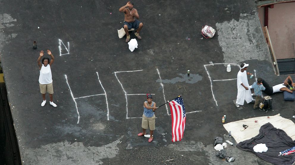 New Orleans-bor står på ett hustak i väntan på att bli räddade undan Katrina. Över 1.800 människor dog när Katrina svepte över USA:s sydstater.