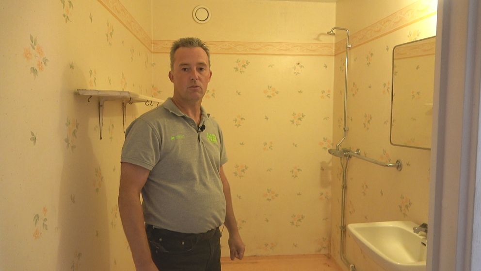 Man som står i ett av badrummen som behöver renoveras i Långshyttan