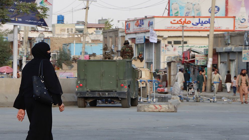 En kvinna passerar en av talibanernas vägspärrar i Kabul, Afghanistan.