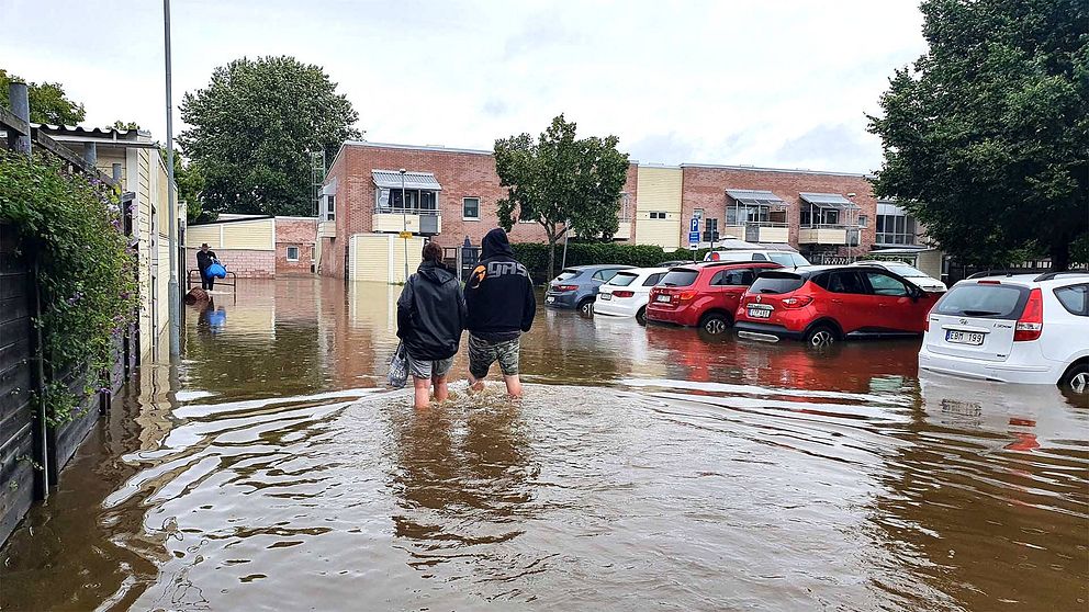 Två personer vadar i vatten i bostadsområde, Gävle. Foto: SVT