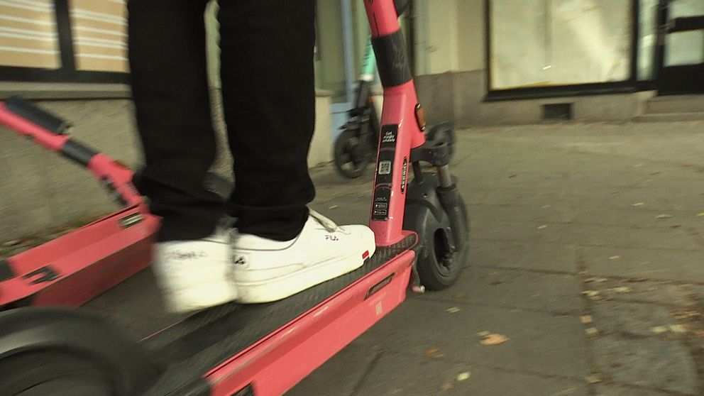 En person sparkar iväg med sin elsparkcykel.