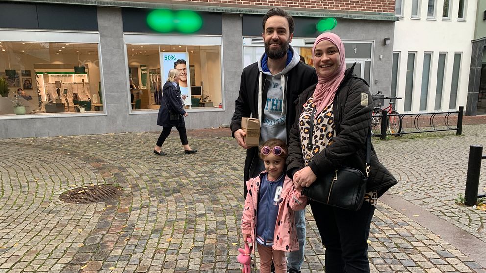 Bild på en familj som står på en gågata