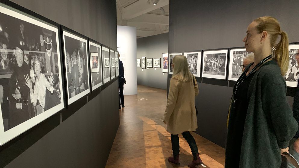 Personer tittar på en utställning av svartvita fotografier