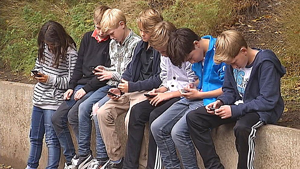 Barn med mobiler på stenmur