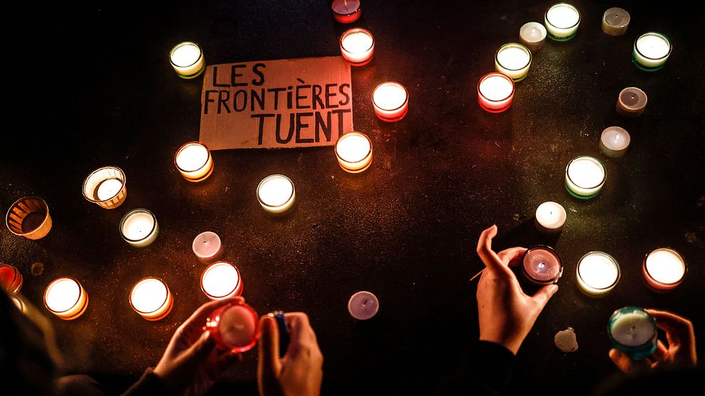 Meddelandet ”gränser dödar” omringas av tända ljus under en demonstration i Paris, Frankrike, som hölls kort efter att minst 27 migranter omkom under sin färd till England.