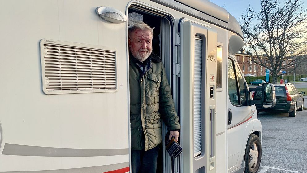 Man som står i dörren till en vit husbil