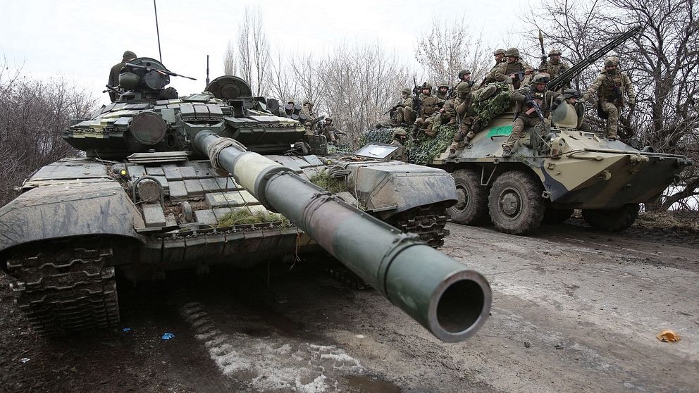En stridsvagn och en bandvagn med soldater i Ukraina. Samma dag som ryssland anfallit Ukraina.