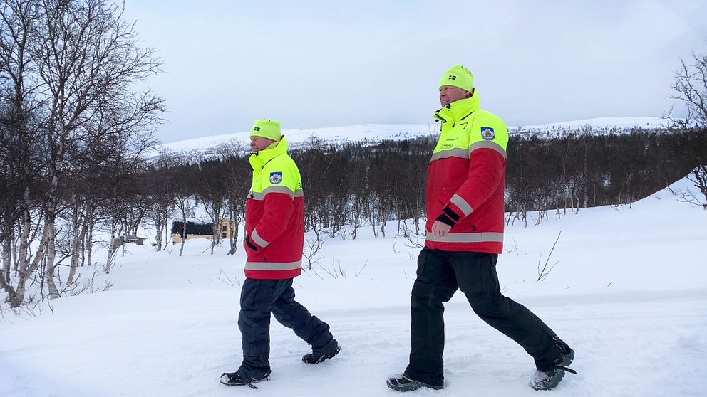 Fjällräddarna Mikael Westerdal och Stefan Korssjön går sida vid sida ner mot Grövelsjön. Det är vinter.