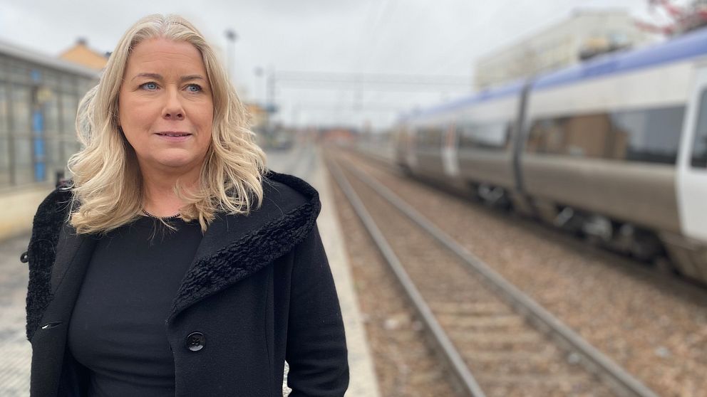 Bild på Mälardalstrafiks vd, Helena Ekroth. Hon tittar ut mot tågrälsen vid tågstationen i Eskilstuna.