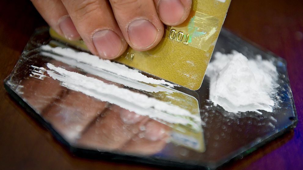 En person delar upp linor av kokain med hjälp av ett kreditkort.