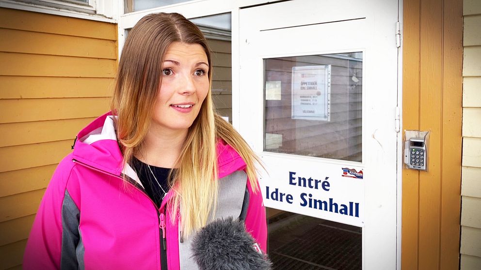 En kvinna står framför dörren till simhallen i Idre.