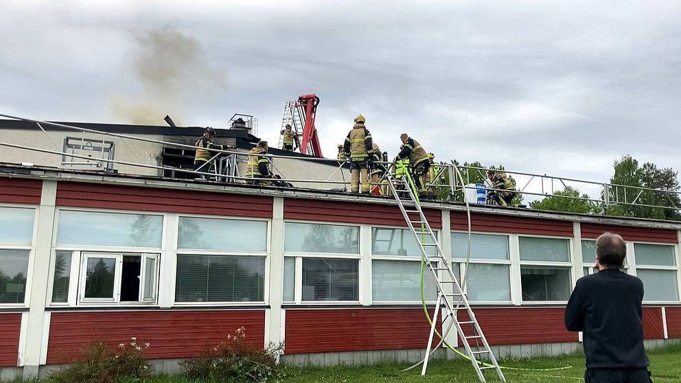Brandmän på taket av en skolbyggnad.