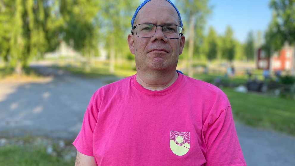 En man i glasögon och t-shirt.