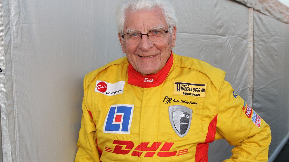 Erik Berger, 90, poserar klädd i gul racingdräkt.