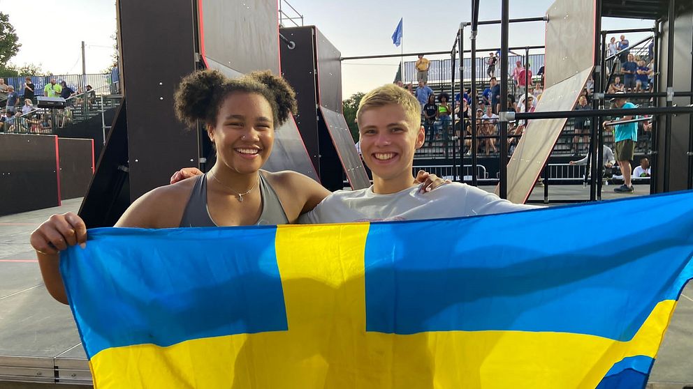 Miranda Tibbling och Elis Torhall håller upp den svenska flaggan.
