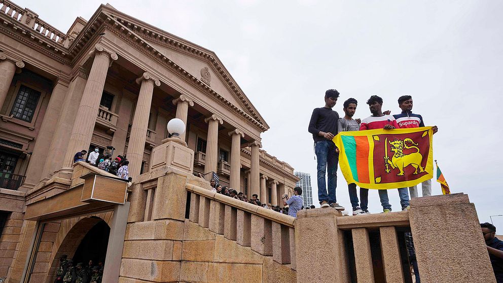 Demonstranter håller en flagga vid president Gotabaya Rajapaksas stormade kontor i huvudstaden Colombo den 11 juli.
