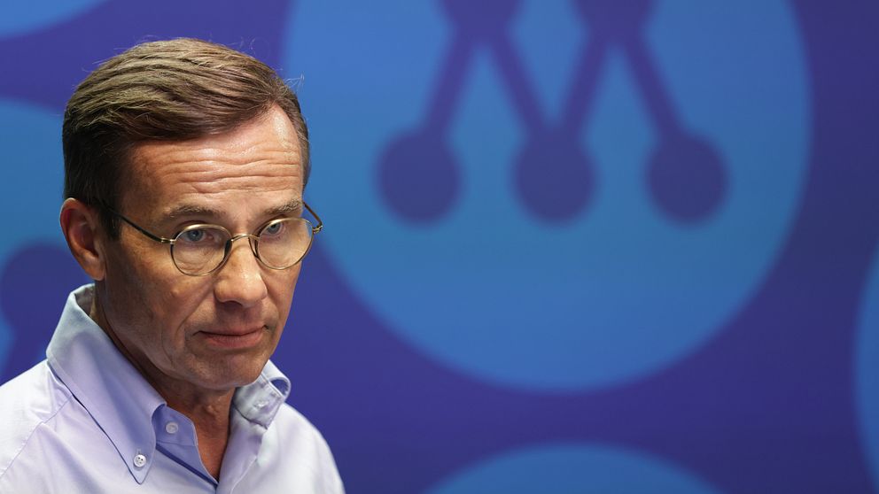 Ulf Kristersson framför M-logga.