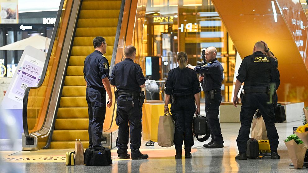 Poliser stående inne på Emporia efter dödsskjutningen.