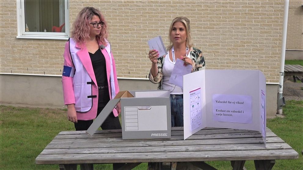 En bild på två kvinnor som visar hur det går till att rösta hemma.