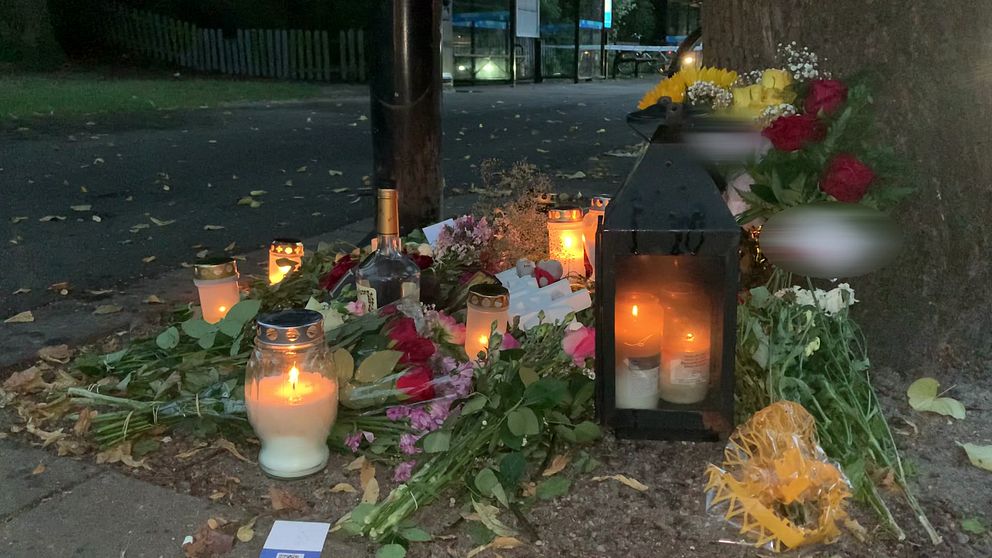 Blommor och ljus på en minnesplats i Halmstad efter det misstänkta knivmordet