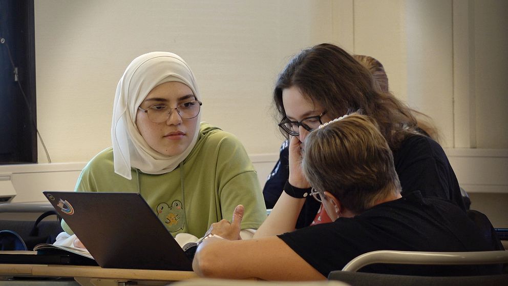 Två elever får hjälp av sin engelskalärare på gymnasiet i Emmaboda.