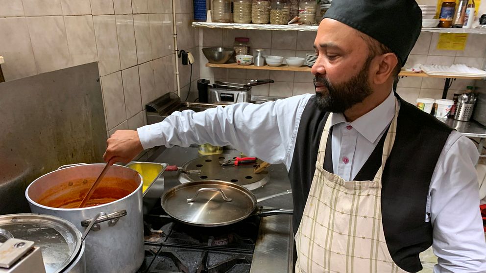 en man står och lagar soppa på en restaurang